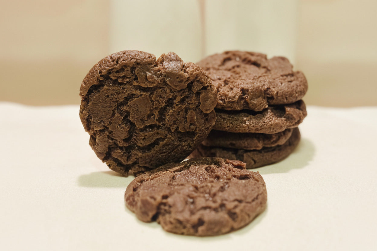 Stack of chocolate cookies on a white surface with a blurred background