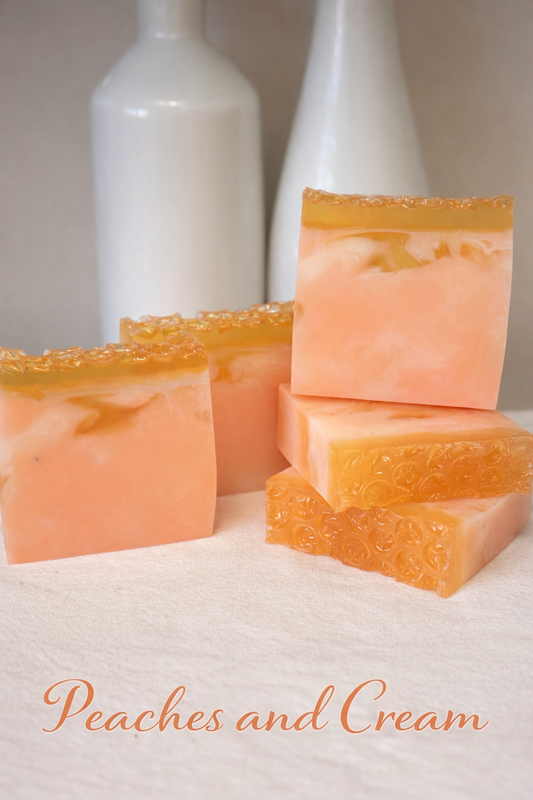 Stack of peach-colored soap bars with a 'Peaches and Cream' label on a white background