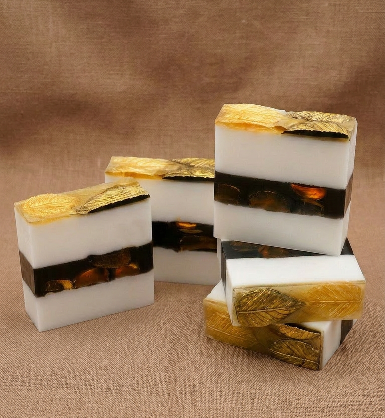 Decorative soap bars with gold and black accents on a brown fabric background
